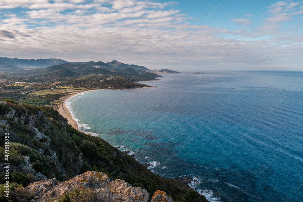 View over Losari beach and the turquoise Mediterranean sea in the Balagne region of Corsica with Ile Rousse in the distance