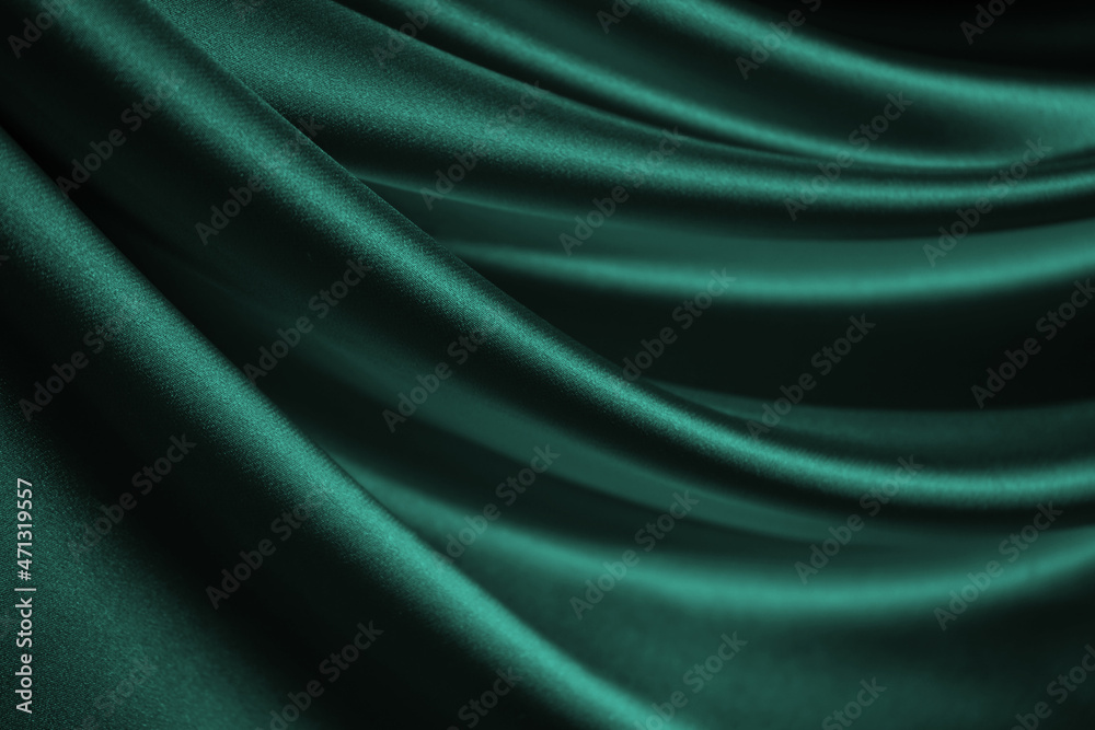Blue green silk satin. Soft, wavy folds. Shiny fabric surface. Luxurious emerald green background with copy space for design. Web banner. Birthday, Christmas, Xmas, Valentine, holiday, concept.