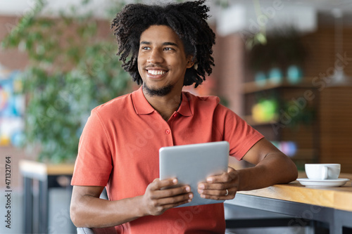 Happy Young Black Man Relaxing With Digital Tablet At Table In Cafe