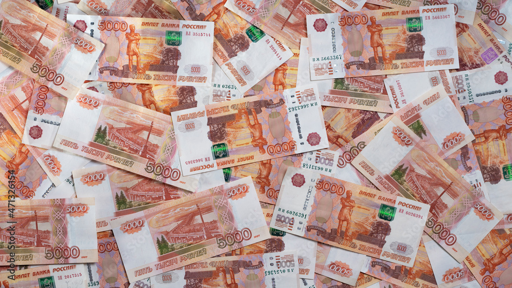 A lot of Russian money of five thousandth bills lies on the table, top view. A lot of Russian money of five thousandth bills lies on the table, top view.