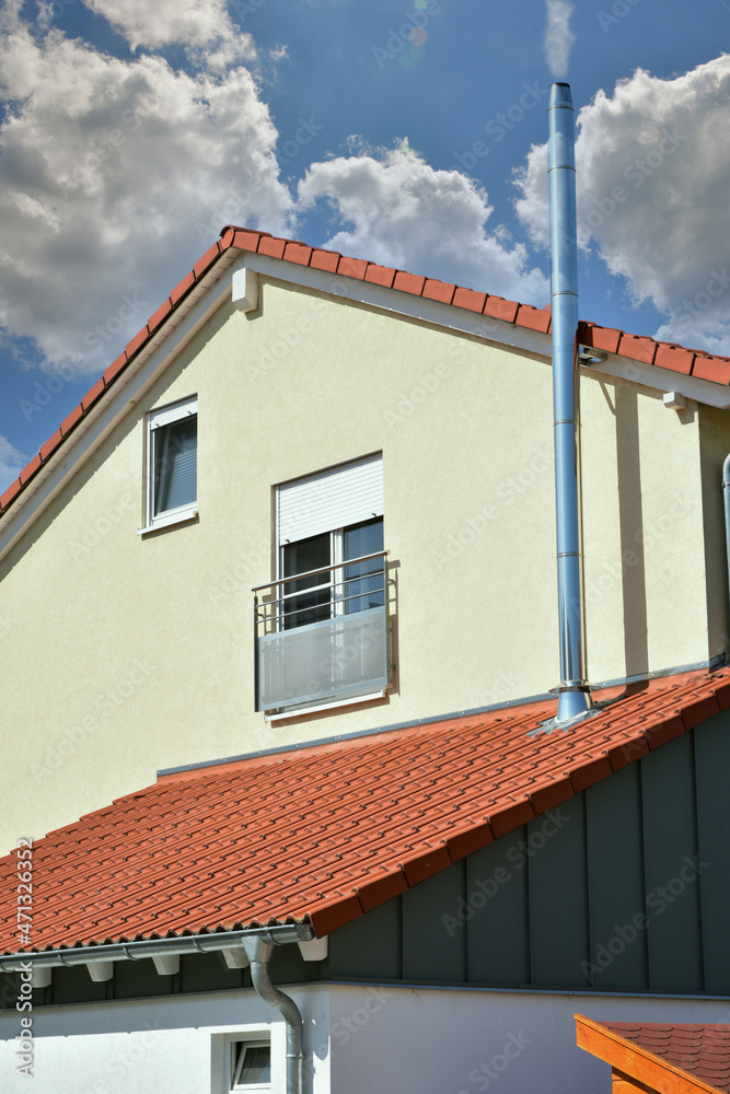 Schornstein, Außenkamin aus Edelstahl an der Fassade eines Wohngebäudes Schornstein, Außenkamin aus Edelstahl an der Fassade eines Wohngebäudes