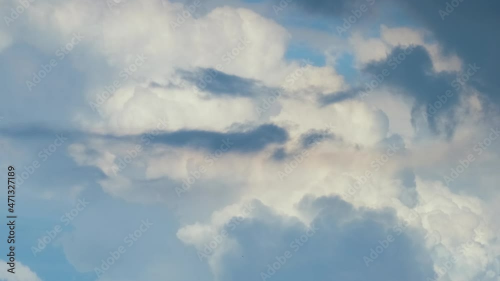 Bright landscape of white puffy cumulus clouds forming and changing under strong wind on blue sky Bright landscape of white puffy cumulus clouds forming and changing under strong wind on blue sky