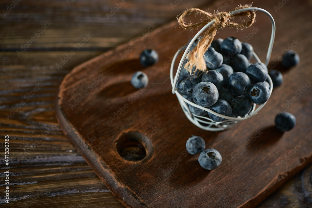 Tiny basket of blueberries on a wooden background Tiny basket of blueberries on a wooden background