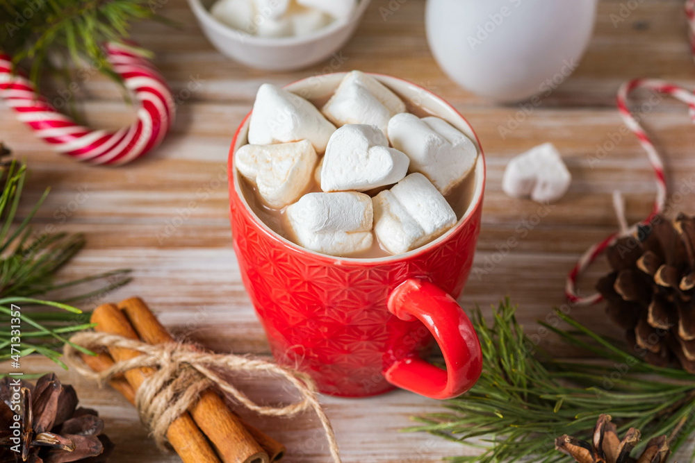 Fragrant cocoa with marshmallows in a red cup in Christmas decor on a wooden background. Merry Christmas concept. Fragrant cocoa with marshmallows in a red cup in Christmas decor on a wooden background. Merry Christmas concept.