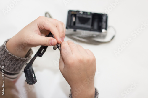 Dismantling the camera for repair. Child examines the device