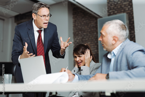 Quadro em tela Angry boss scolding his colleague during a business meeting in the office