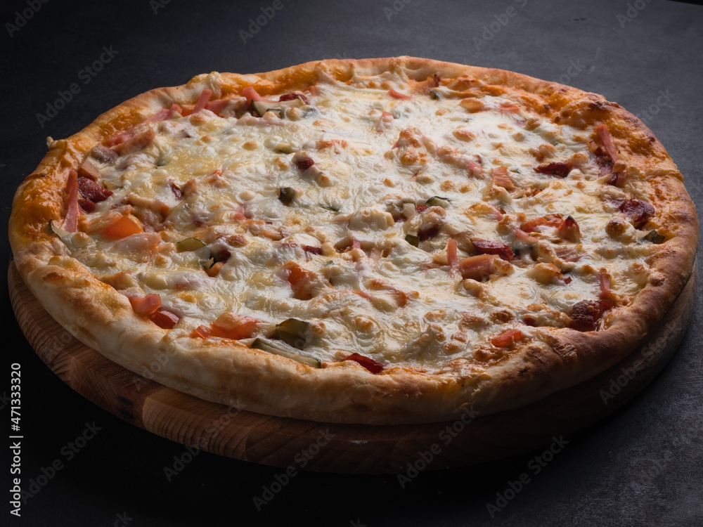 Homemade pizza with ham, cheese, tomatoes. Italian food, natural ingredients.