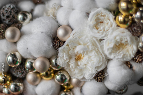 Stylish White Christmas Wreath, holiday decoration. Cotton Wreath. Christmas wreath made of cotton, golden balls, pine cones and big beautiful golden bow.