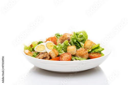 Caesar salad with chicken, croutons and parmesan in a plate isolated on a white background photo