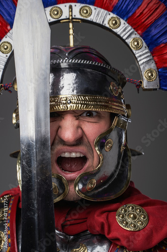 Screaming legionary with short sword against gray background