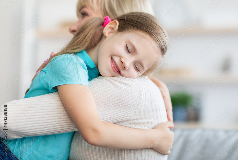 Happy mature woman embracing her granddaughter, closeup