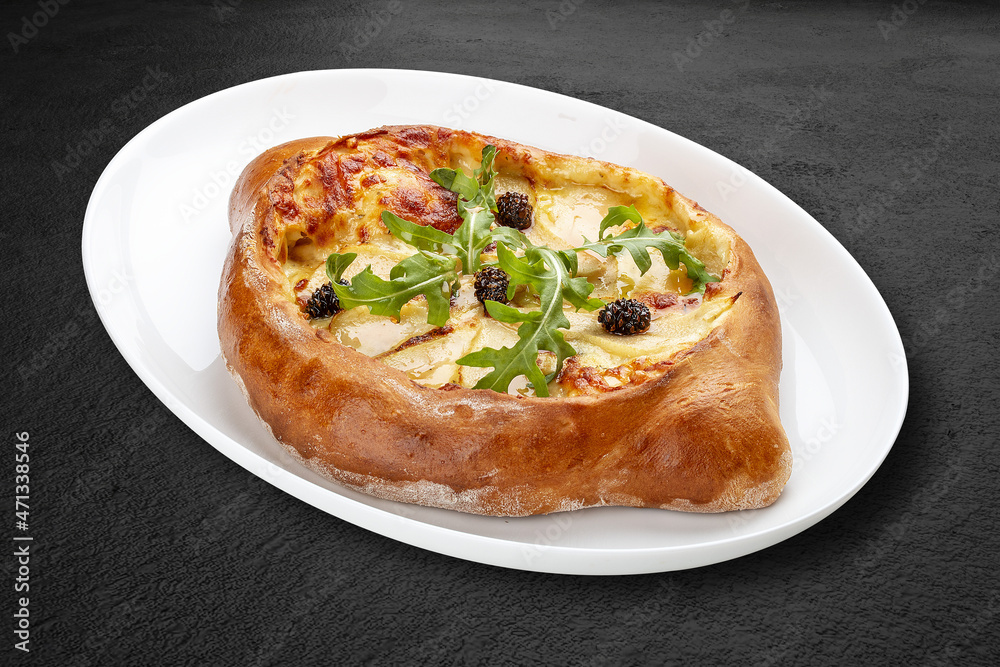 Traditional Georgian cuisine. Adjarian khachapuri. Isolated on a black background.
