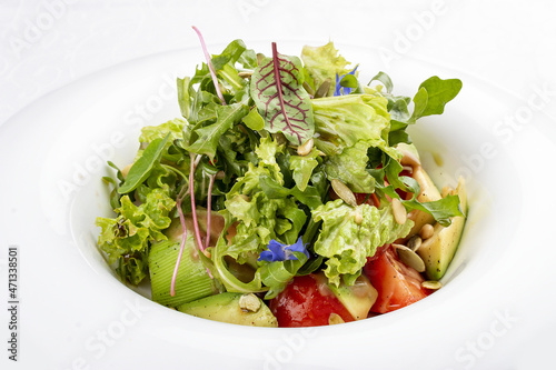 Salad with avocado and pine nuts. Isolated on a white background.