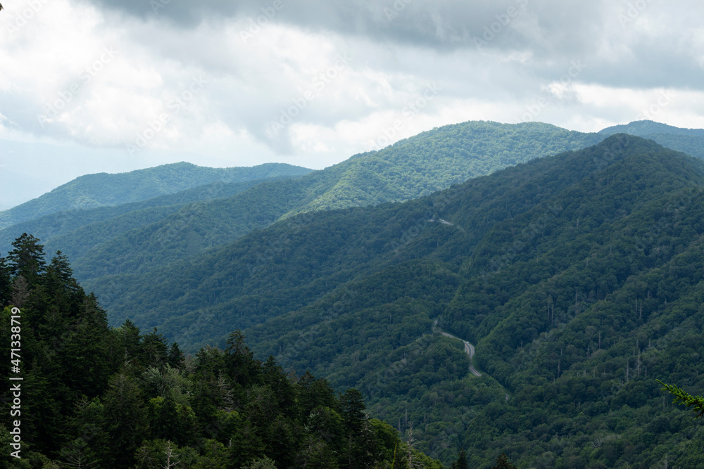 The Great Smoky Mountains with clouds above and a road below.