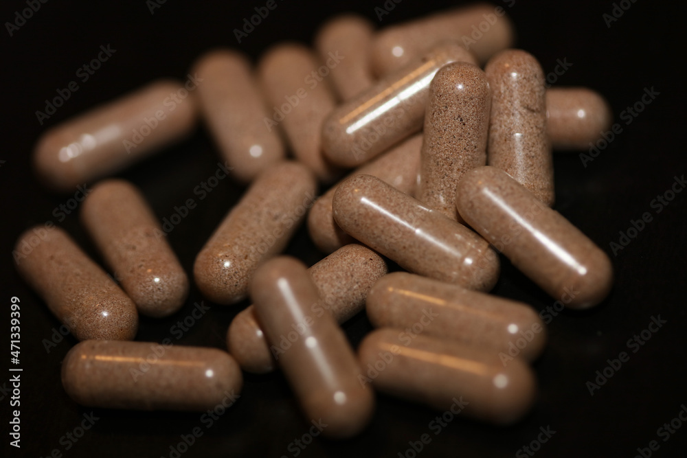 Transparent capsules filled with brown vitamins powder close up background high quality big size prints