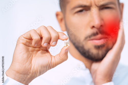 Photos Man feeling pain after tooth extraction or tooth removal surgery