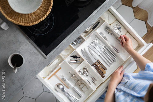Foto Top view closeup housewife hands tidying up cutlery in drawer general cleaning a