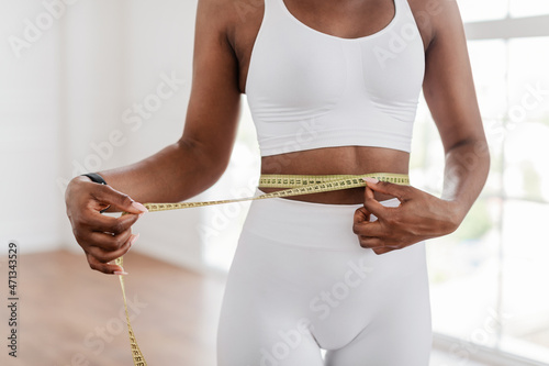 Black Woman Measuring Waist With Tape. Dieting Slimming Concept photo