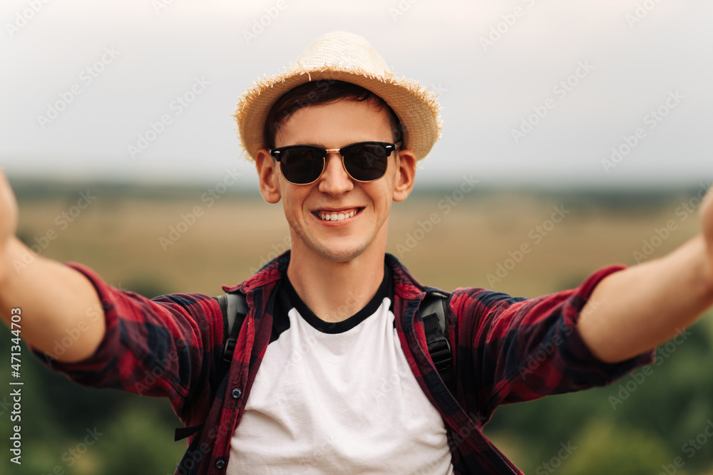 male tourist in sunglasses, makes a selfie while walking in the woods. A traveler leading a healthy active lifestyle male tourist in sunglasses, makes a selfie while walking in the woods. A traveler leading a healthy active lifestyle