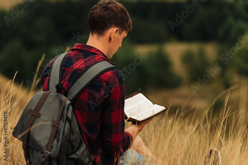 Valokuvatapetti Reading the Bible outdoors in nature