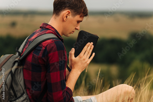 man closed his eyes, prayed in the open air, holding the Bible in his hands. holding a Bible in his hands