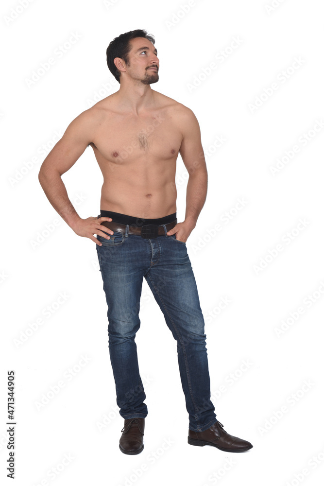 man shirtless and with blue jeans  looking side on white background