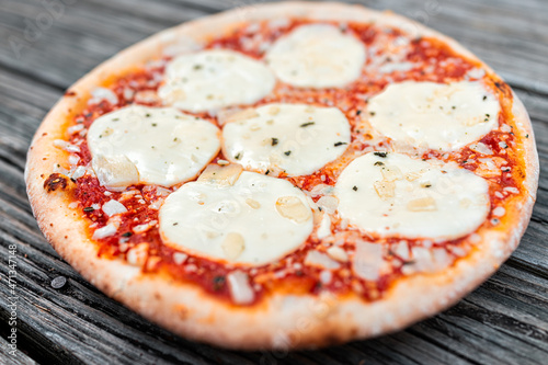 Traditional Italian baked hot pizza from Italy closeup with melted mozzarella provolone cheese slices, basil sprinkles and red tomato sauce