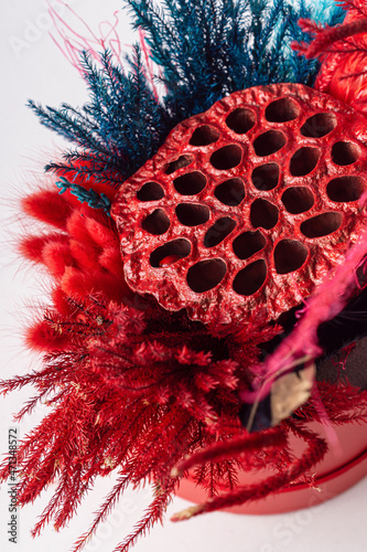 Dried flowers composition with lotus, lagurus and juniper in red hat box. Bright bouquet in round box photo