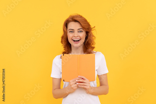 glad woman hold book on yellow background, knowledge