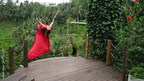 Pretty asian woman swing in long red dress in slowmotion on rice terrace in Bali Indonesia. High quality fullhd footage