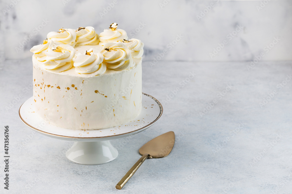 Beautiful tasty white cake with white cream; on cake stand
