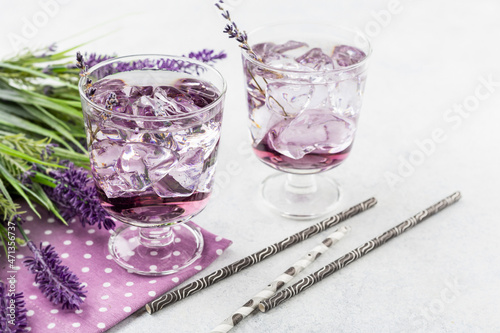 Purple cocktail drink in a glassess on white background with flowers photo