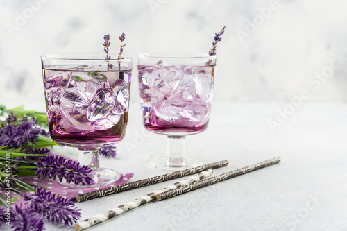 Purple cocktail drink in a glasses on white background with flowers