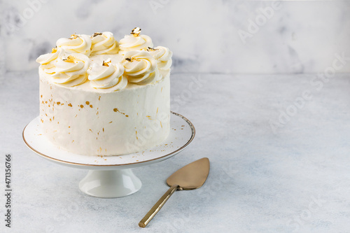 Beautiful tasty white cake with white cream; on cake stand