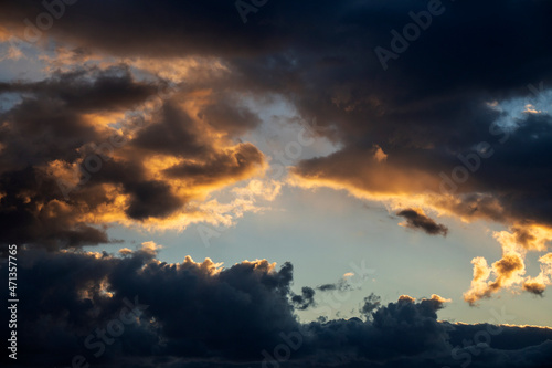 Dramatic cloudscape at sunset. Sunset with sun rays. Evening sky with dramatic clouds view. Gradient color. Sky texture, abstract nature background