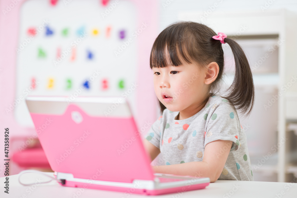 young girl using laptop for online learning during lockdown time