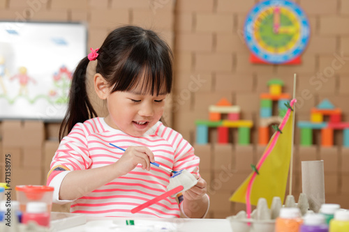 young girl painting egg carton glasses craft at home