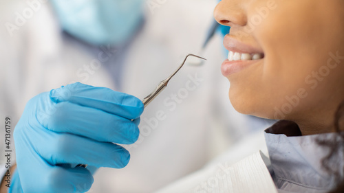 Dentist Holding Dental Probe Instrument, Ready For Check Up With Female Patient