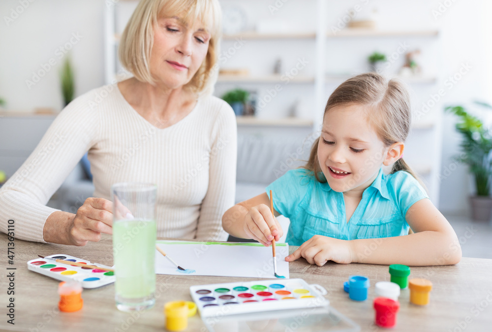 Mature woman and girl drawing with watercolor painting at home Mature woman and girl drawing with watercolor painting at home
