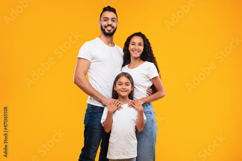 Arabic Family Hugging Standing Posing Together Over Yellow Background © Prostock-studio