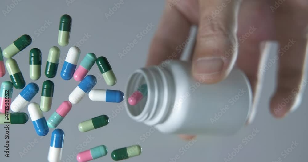 Pills bottom view. A woman pout her pills on the glass, bottom view. Pills bottom view. A woman pout her pills on the glass, bottom view.