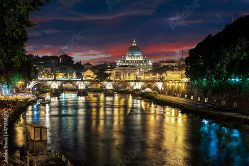 Night view at St. Peter's cathedral in Rome with reflection on Tiber river