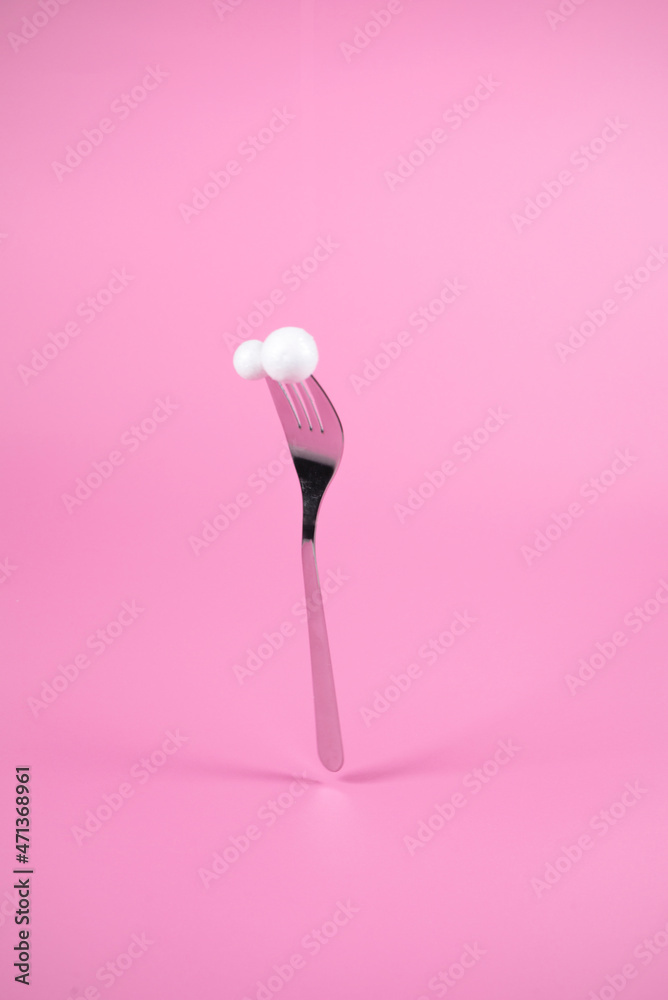 Fork with snowballs on pastel pink background. Christmas and New Year idea. Minimal abstract winter holidays concept. Fork with snowballs on pastel pink background. Christmas and New Year idea. Minimal abstract winter holidays concept.