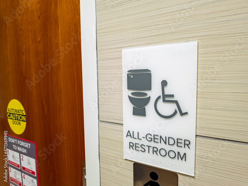 Close up isolated image showing all gender restroom sign at the entrance of a public toilet. These facilities are getting more common and popular acrross the country. photo