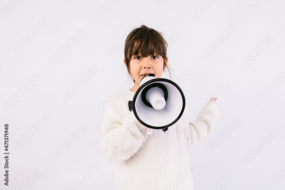 Little black haired girl wearing white sweater with bow tie, speaking through a white megaphone. Little black haired girl wearing white sweater with bow tie, speaking through a white megaphone.