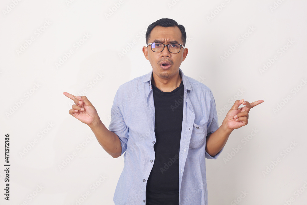 Portrait of indecisive, confused asian man asking show way, pointing sideways, left and right, asking what variant pick Portrait of indecisive, confused asian man asking show way, pointing sideways, left and right, asking what variant pick