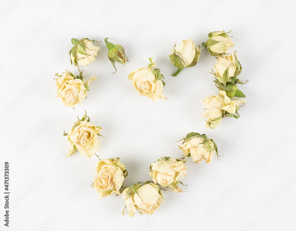 Heart made with beige roses and green leaves isolated on white background. Flat lay, top view