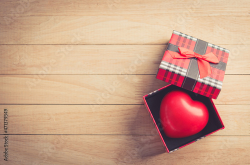 gift box with a red heart inside on a white old wooden table. Valentine day, copy space for text.