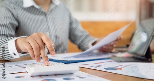 Businesswoman working at office with document on her desk, doing planning analyzing the financial report, business plan investment, finance analysis concept.
