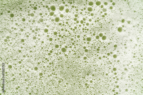Texture of white foam on a green background. photo